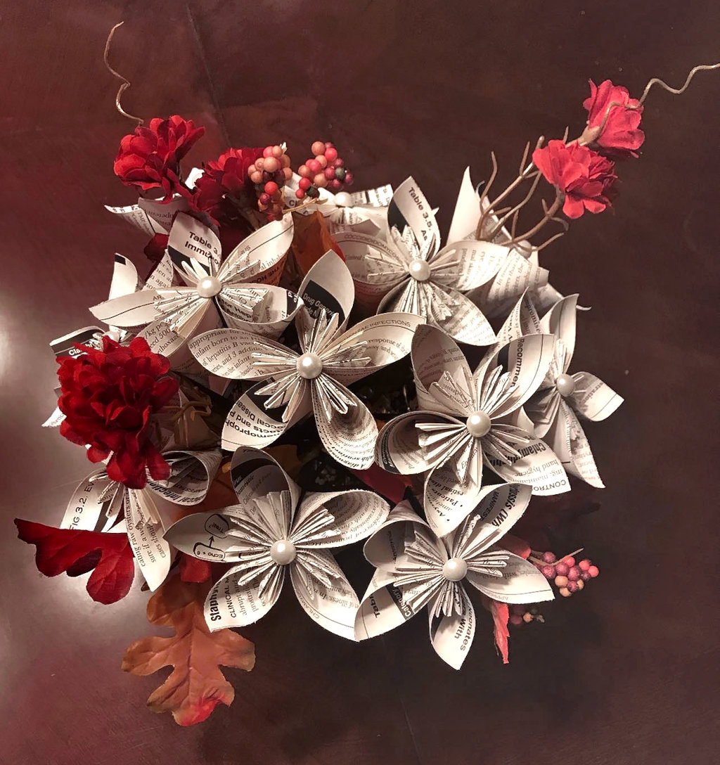 A bouquet of paper flowers arranged with red artificial flowers.